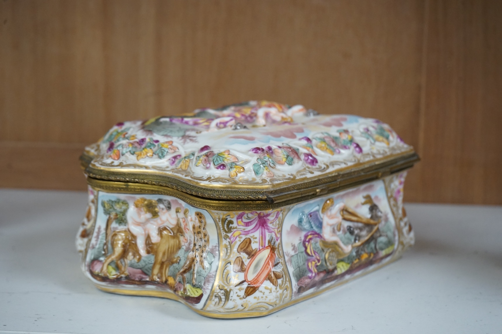 An ornate Neapolitan Capodimonte porcelain box with gilt mounts, 22cm wide, 11cm high